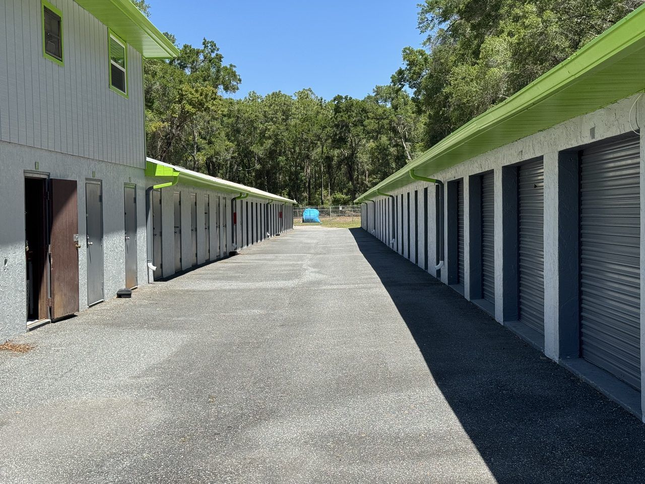 Paved drive aisle inside the gated Cortez Self Storage lot in Brooksville, FL — wide enough to back in a boat trailer, RV, or work truck.